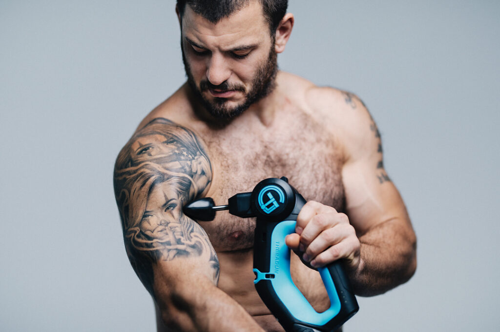 Mathew Frasern utilizando una Pistolas de masaje theragun